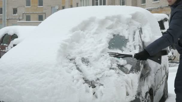 Mężczyzna czyszczenia samochodu ze śniegu — Wideo stockowe