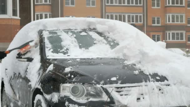 Mann reinigt Auto vom Schnee — Stockvideo