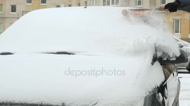 Мужчина убирает машину от снега — стоковое видео