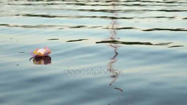Pink water lily with candle on the water — Stock Video