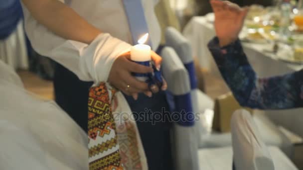Recién casados sostienen vela encendida — Vídeo de stock