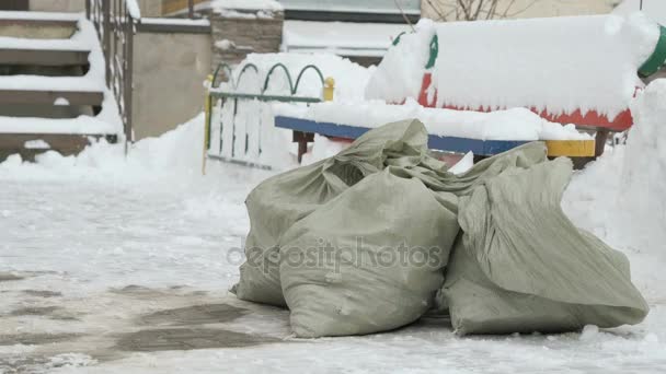 Konstruksi sampah dalam tas berbaring di salju — Stok Video