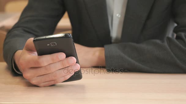 Hombre joven desconocido sosteniendo teléfono inteligente negro — Vídeos de Stock