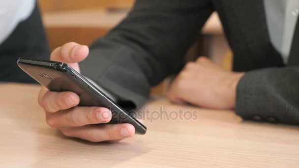 Hombre joven desconocido sosteniendo teléfono inteligente negro — Vídeos de Stock