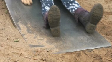 Küçük çocuk bir çelik slayt üzerinde açık havada hareket