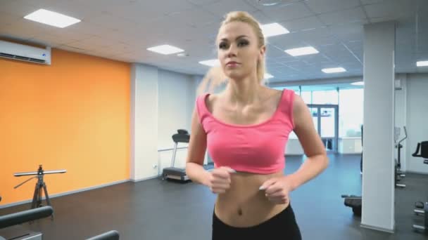 Sportlerin Blondine engagiert sich im Fitnessstudio — Stockvideo