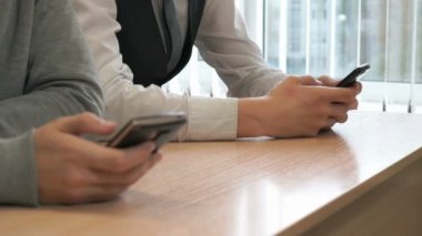 İki öğrenci çocuklar siyah akıllı telefonlar ile