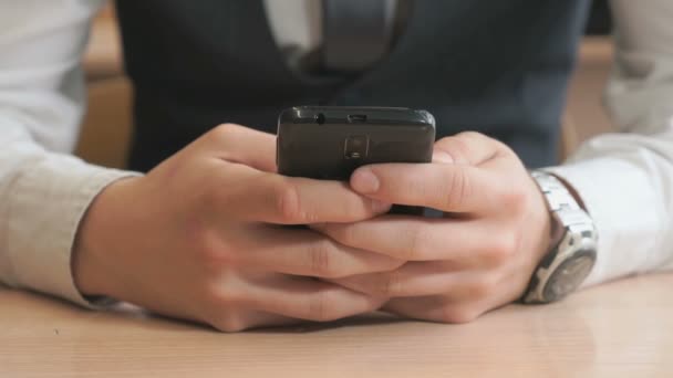 Estudiante desconocido sosteniendo teléfono inteligente negro — Vídeos de Stock