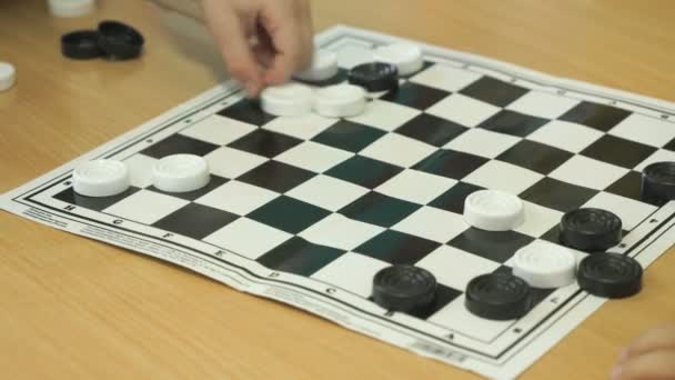 The child plays checkers in kindergarten indoors — Stock Video