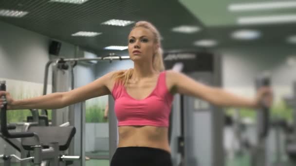 Hermosa chica rubia ocupada en el gimnasio en el interior — Vídeo de stock