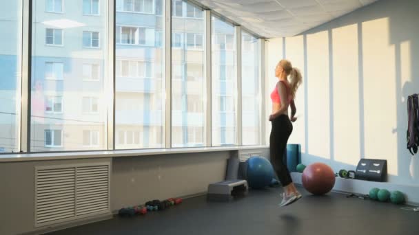 Sportlerin Blondine engagiert sich im Fitnessstudio — Stockvideo