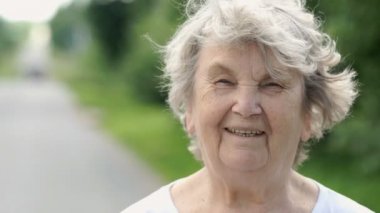 Olgun yaşlı kadın açık havada gülümseyen portresi
