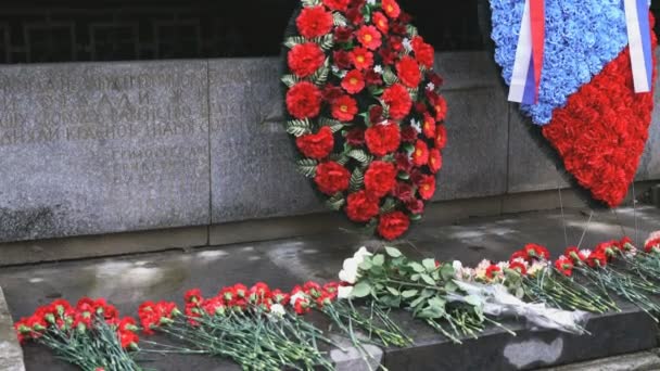 Blumen am Denkmal mit den Namen gefallener Soldaten — Stockvideo
