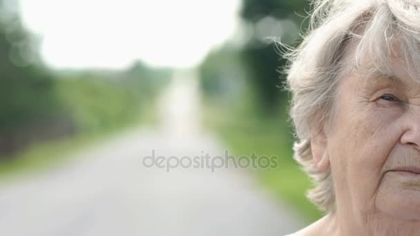 Demi-visage de la vieille femme sérieuse à l'extérieur — Video