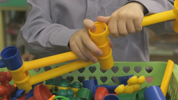 Menino joga desenvolvendo designer de brinquedos dentro de casa — Vídeo de Stock