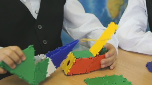 Мальчик играет в развивающего игрушечного дизайнера в помещении — стоковое видео