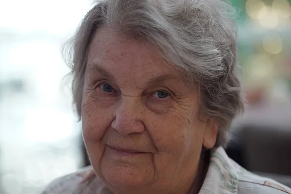 Porträt einer alten lächelnden Frau im Café lizenzfreie Stockbilder