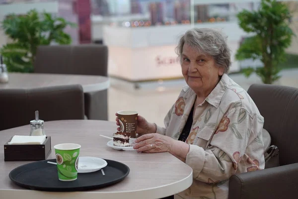 Porträt einer alten lächelnden Frau im Café Stockbild