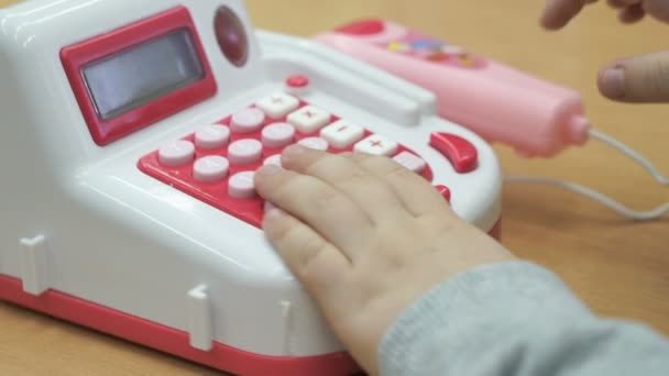 Маленький хлопчик грає з іграшковим телефоном у приміщенні — стокове відео