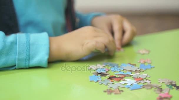 Nieznany dziecko zbierania zagadki przy stole — Wideo stockowe