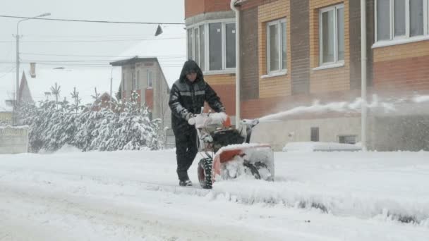 Hombre quitando nieve con máquina de arado de nieve — Vídeos de Stock