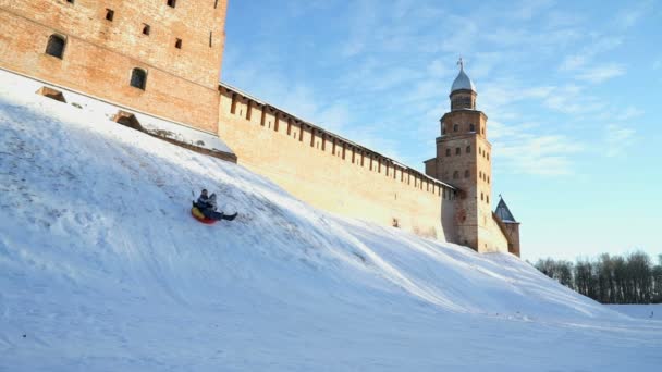 Kinderen rodelen bergafwaarts in de winter — Stockvideo