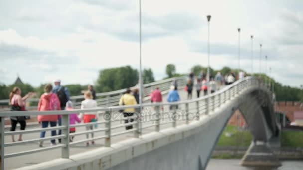 Gente caminando sobre un puente peatonal sobre el río — Vídeos de Stock