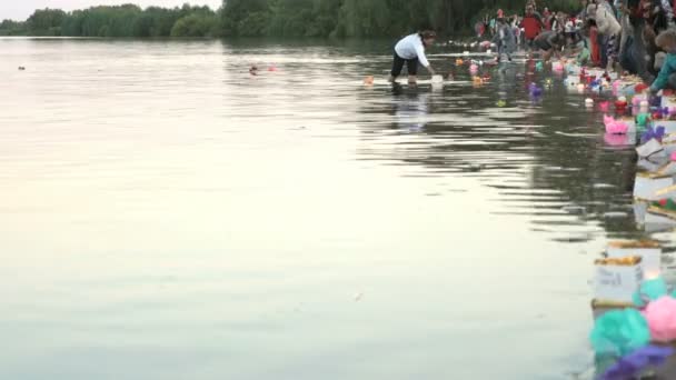 Många människor släppa ut näckrosor i vatten — Stockvideo