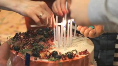 Eller kişi Işık mumlar pastanın üzerinde