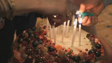 Eller kişi Işık mumlar pastanın üzerinde