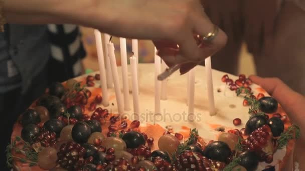 Manos de persona encendiendo velas en pastel de bodas — Vídeos de Stock