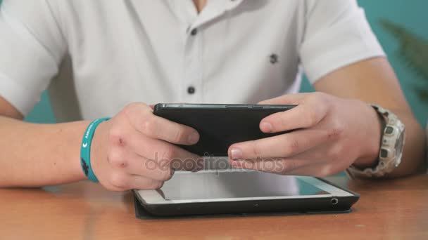 Close-up de mãos de homens segurando smartphone preto — Vídeo de Stock