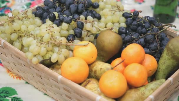 Dark and green grape, oranges, pears in wooden box — Stock Video