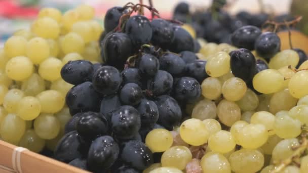 Спелый черный и зеленый виноград в деревянной коробке — стоковое видео