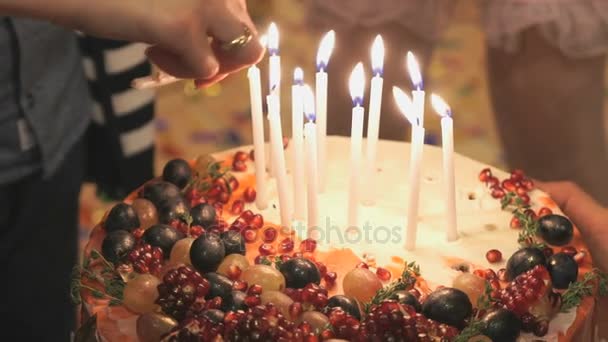 Ręce osoby oświetlenie świeczki na tort weselny — Wideo stockowe