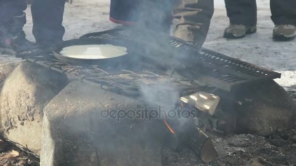 Russische Pfannkuchen auf der Pfanne am Lagerfeuer