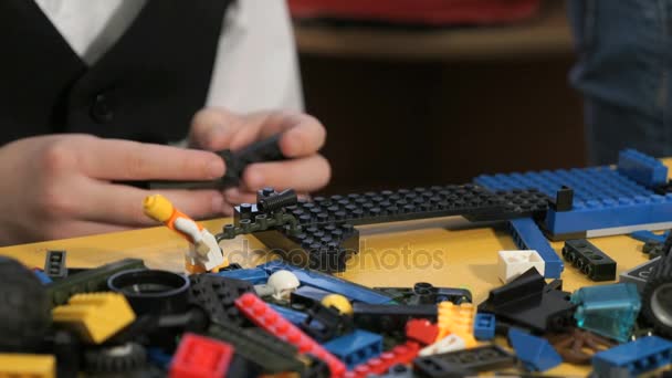 Handen van een onbekende jongen spelen met het bouwen van kit — Stockvideo