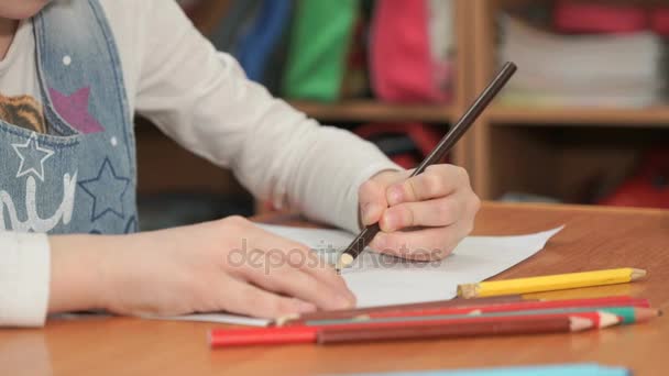छोटी लड़की रंग पेंसिल का उपयोग करके तस्वीरें खींचती है — स्टॉक वीडियो