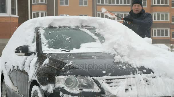 Mann reinigt Auto vom Schnee — Stockvideo