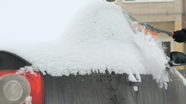 Mann reinigt Auto vom Schnee — Stockvideo