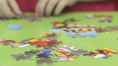 Küçük çocuk resim bulmacalar toplar.