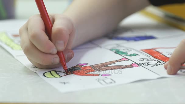 Неизвестная маленькая девочка рисует картины войлочной наконечницей — стоковое видео