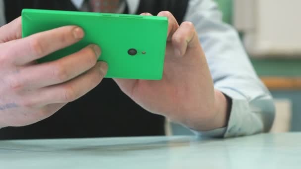 Un écolier inconnu tenant un smartphone vert — Video