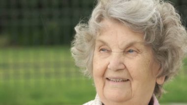 Olgun yaşlı kadın açık havada gülümseyen portresi