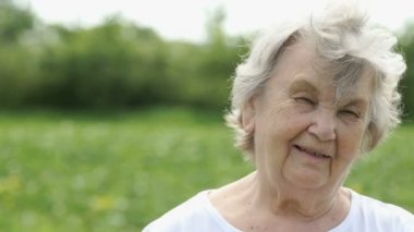 Gülümseyen olgun yaşlı kadın saçını düzeltiyor