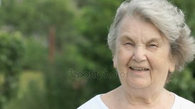 Olgun yaşlı kadın açık havada gülümseyen portresi