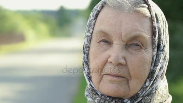 Задумчивый взгляд серьезной пожилой женщины. Крупный план — стоковое видео
