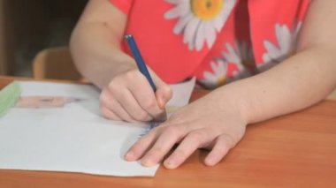 Küçük kız renkli kalemler kullanarak resim çizer