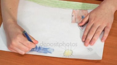 Çocuk renkli kalemler kullanarak resim çizer