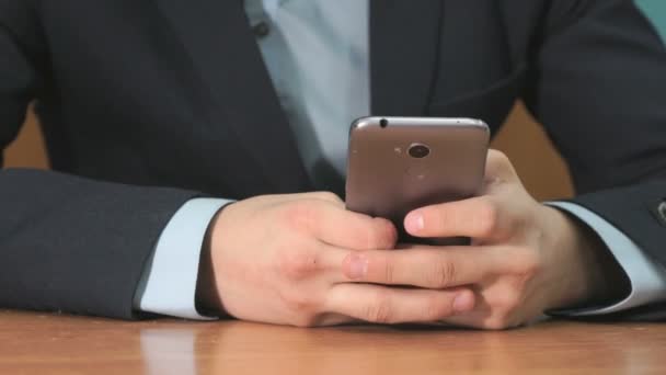 Неизвестный студент держит серый смартфон — стоковое видео
